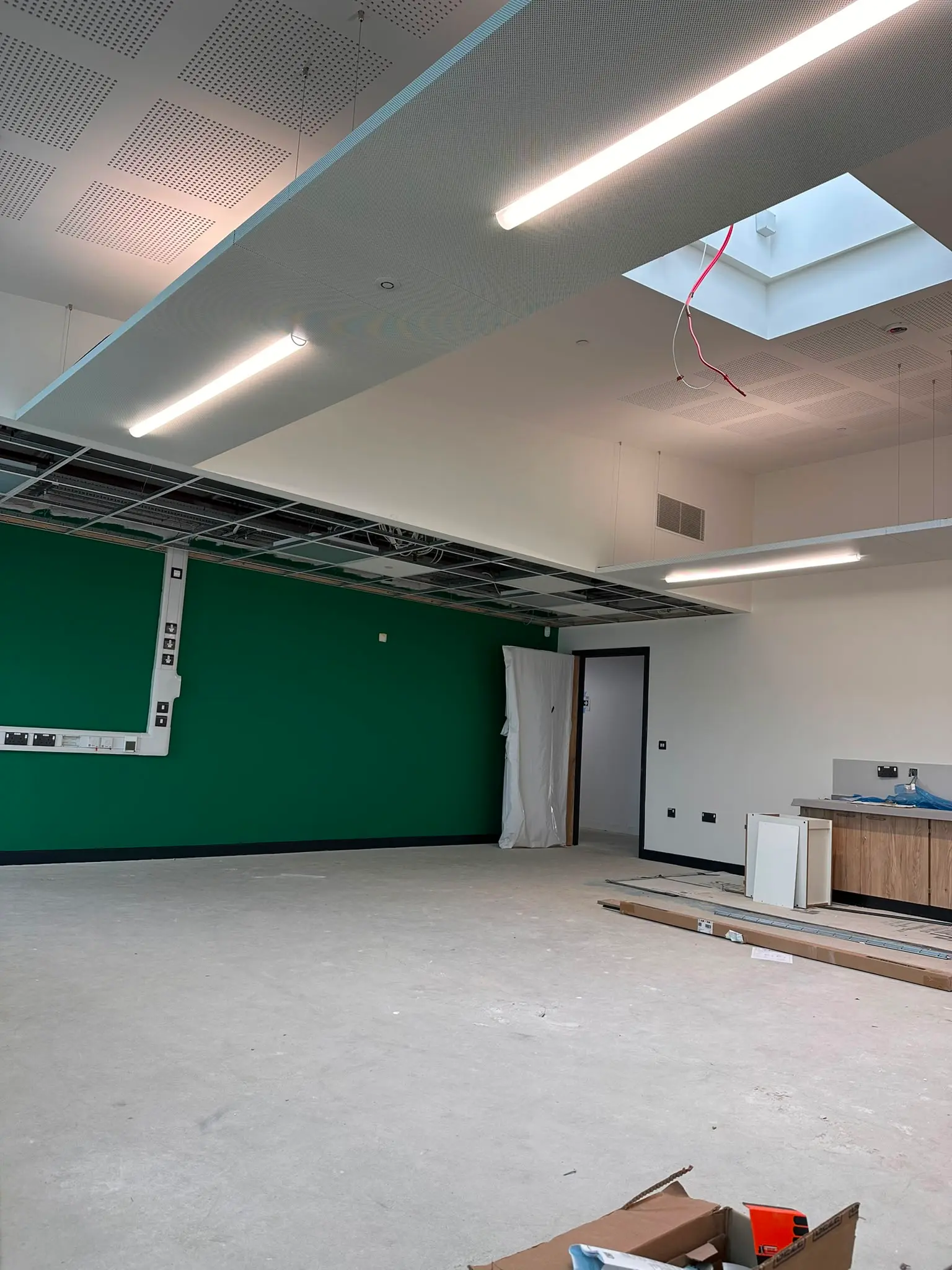 Acoustic suspended ceiling installation with integrated lighting in a commercial office space