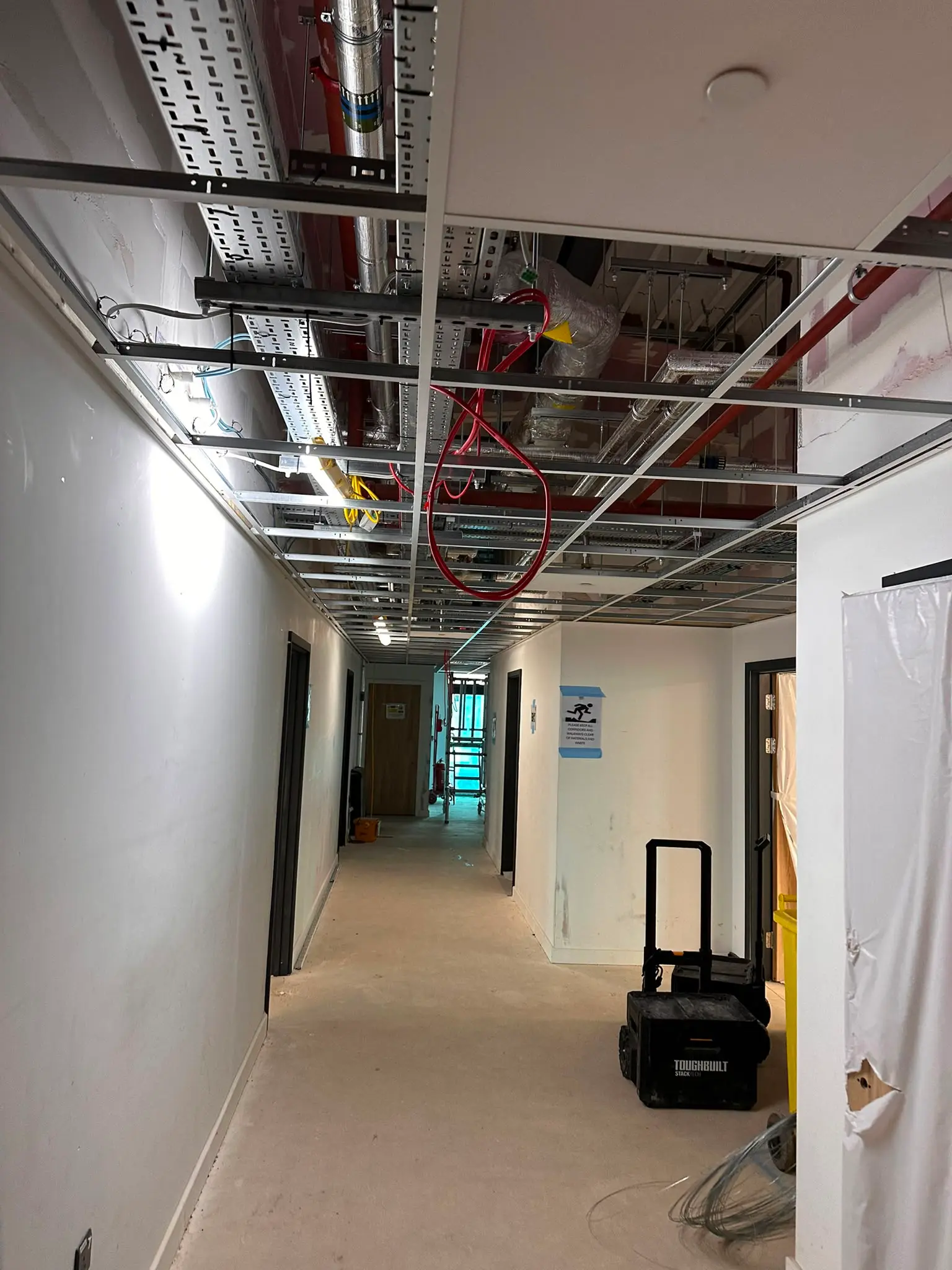 Suspended ceiling grid system installation showing first fix framework and building services