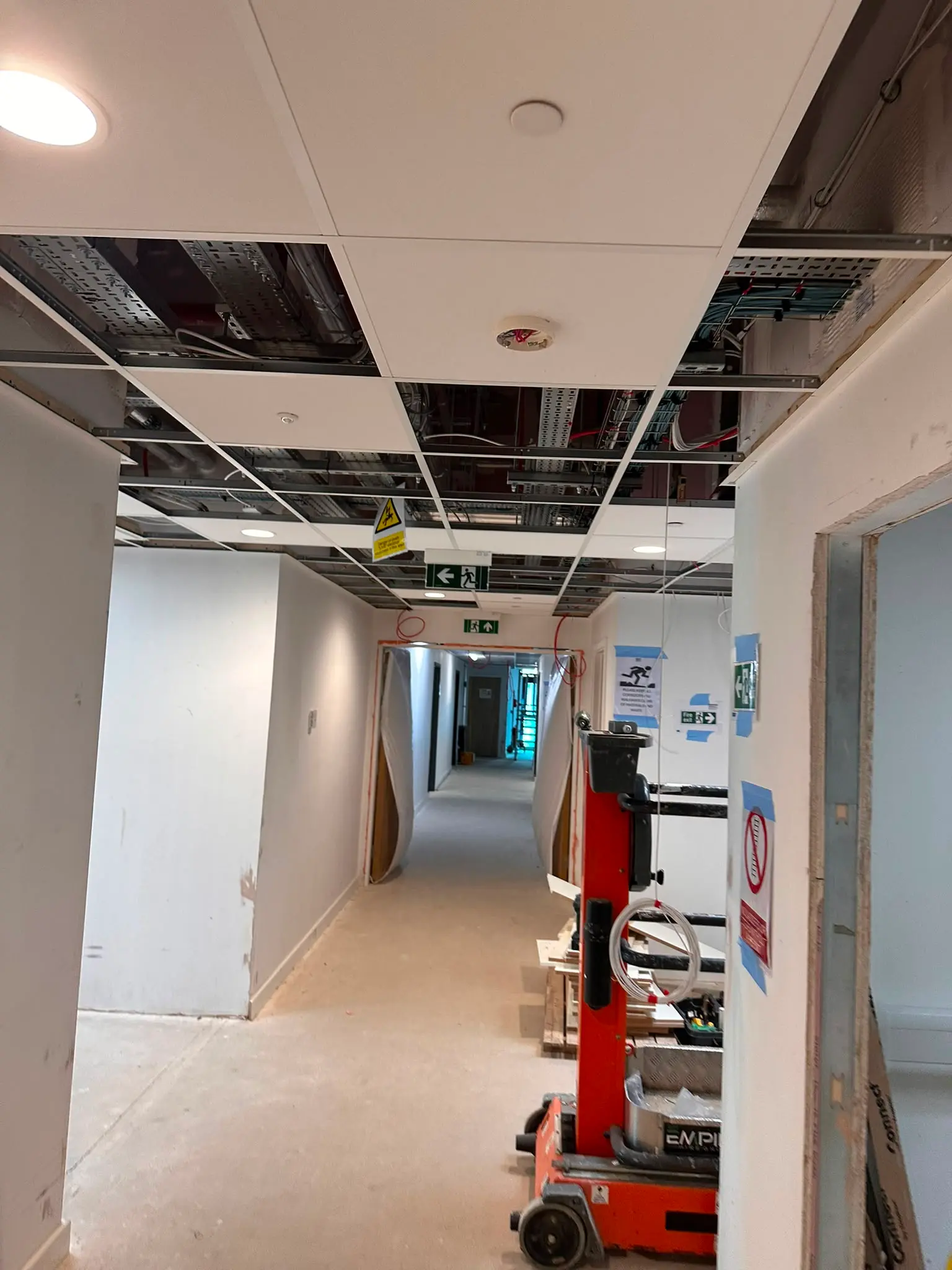 Commercial corridor suspended ceiling installation with acoustic ceiling tiles